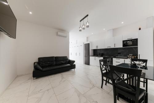 a living room with a black couch and a table at Luxury Apartments-Belochka in Uzhhorod