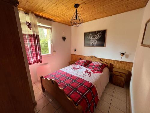 - une chambre avec un lit et une couette rouge et blanche dans l'établissement O' Chênes Rouges GERARDMER - 4-6 pers avec terrasse vue lac et montagne, à Gérardmer