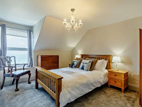een slaapkamer met een groot bed en een kroonluchter bij 2 Bed in Lynton 91409 in Lynmouth