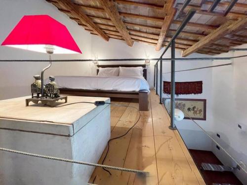 ein Schlafzimmer mit einem Bett und einer roten Lampe auf dem Schreibtisch in der Unterkunft Casa Gastone in Rimini
