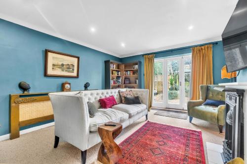sala de estar con paredes azules y sofá blanco en Reigate Gem en Redhill