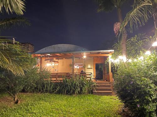 a small house with a porch at night at Casa Araucarias Refugio Natural en la Ciudad in Posadas