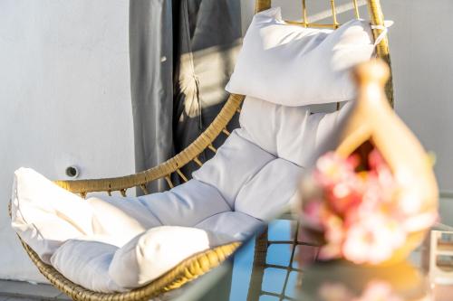 a wicker chair with a pillow and flowers in it at Mar Báltico in Torrevieja