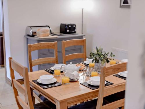 a wooden table with chairs and plates and cups at 3 Bed in Mattersey 91307 in Mattersey