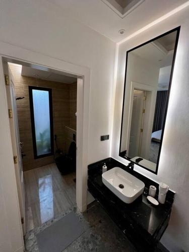 a bathroom with a sink and a large mirror at Onyx residence in Riyadh