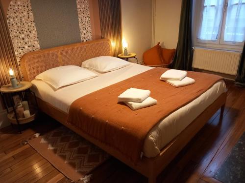 een slaapkamer met een groot bed en 2 handdoeken bij Passage de l'Horloge in Auxerre
