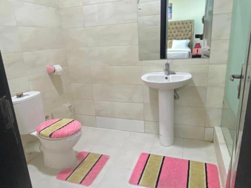 a bathroom with a sink and a toilet and a mirror at Tribeca pod (3 bedroom with swimming pool) V.i Lagos in Lagos