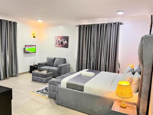 Tribeca pod (3 bedroom with swimming pool) V.i Lagos في لاغوس: غرفة نوم بسرير واريكة وكرسي