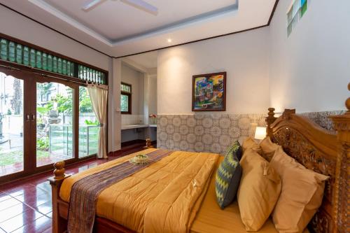 1 dormitorio con 1 cama grande en una habitación en Rahayu Hanoman Ubud, en Ubud