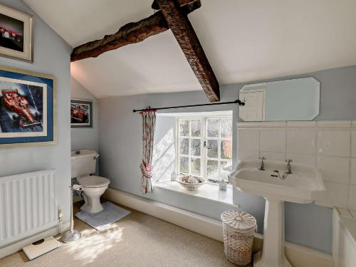a bathroom with a sink and a toilet and a window at 2 Bed in Middleham 91639 in Middleham