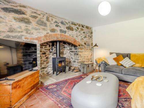 a living room with a stone fireplace and a couch at 4 Bed in Old Churchstoke 91498 in Church Stoke