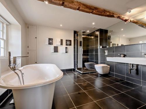 uma grande casa de banho com banheira e lavatório em 5 Bed in Keswick 91503 em Embleton