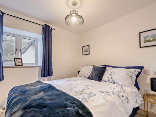 a bedroom with a bed and a window with blue curtains at 2 Bed in Gloucester 91603 in Matson