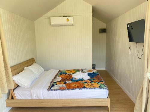 niewielka sypialnia z łóżkiem z telewizorem na ścianie w obiekcie The Pubpa Backyard 
