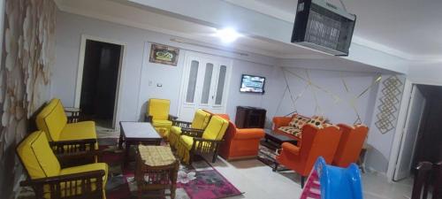 - un salon avec des tables et des chaises colorées dans l'établissement شاليه في قرية هيلو بيتش في الكيلو ٥٠, à Borg El Arab