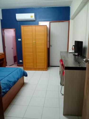 a room with a bedroom with a bed and a desk at Nontharat Mansion in Nonthaburi