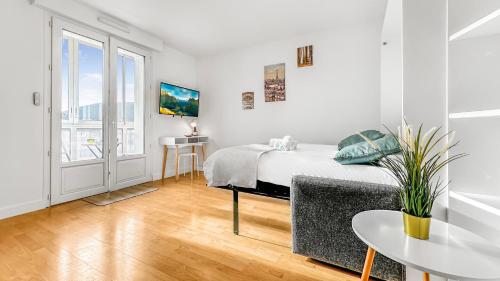 a white bedroom with a bed and a table at COLOC HAPPY PLACE - Belle colocation de 3 chambres - Wifi gratuit in Annemasse
