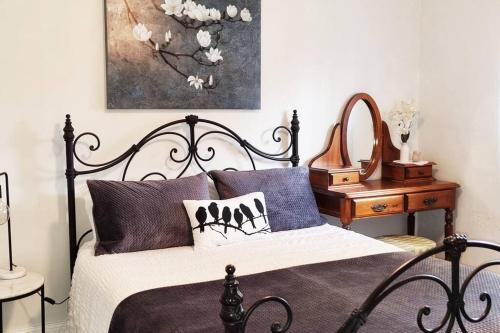 a bedroom with a black and white bed and a table at Blackbird Cottage - Stunning views & farm animals in Tanunda