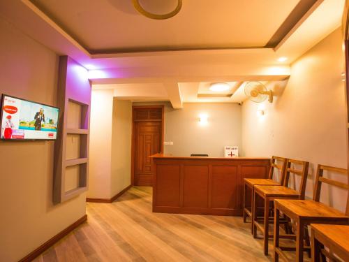 Ngateu的住宿－Medan Hotel，一间带木桌的餐厅和一间拥有紫色灯光的酒吧