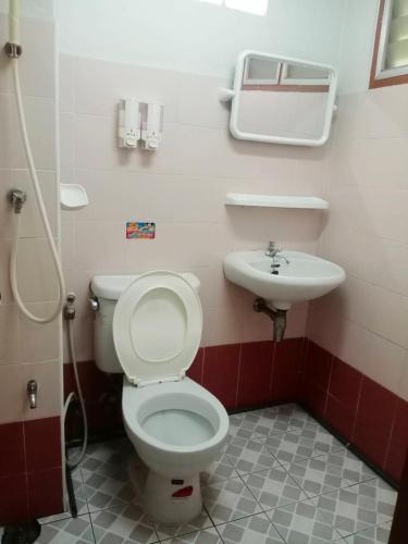 a bathroom with a toilet and a sink at Nontharat Mansion in Nonthaburi
