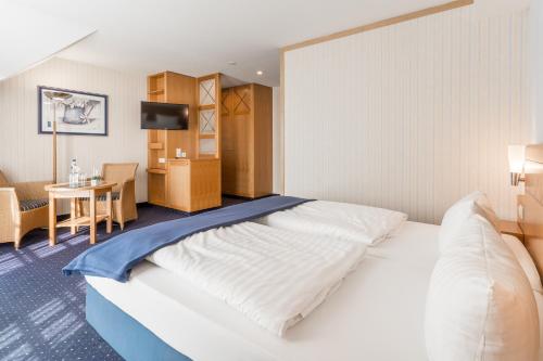 a hotel room with a large bed and a table at Strandhotel Seestern in Baabe