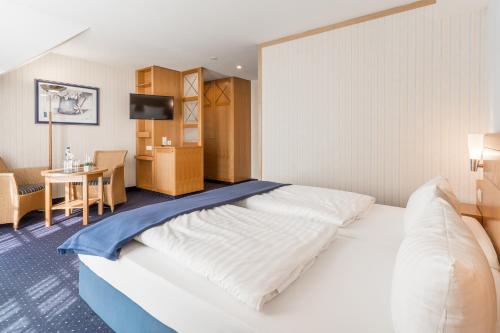 um quarto de hotel com uma cama grande e uma mesa em Strandhotel Seestern em Baabe