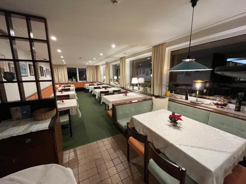 une salle à manger avec des tables et des chaises ainsi qu'une cuisine dans l'établissement Pension Alpina, à Obsteig