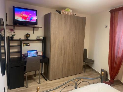 a room with a desk and a cabinet with a television at Archetto-casa vacanze in Enna