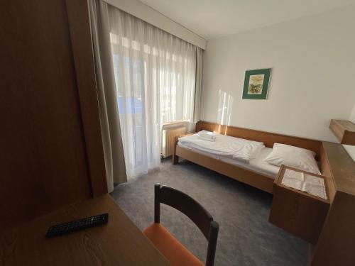 a hotel room with a bed and a window at Pension Alpina in Obsteig