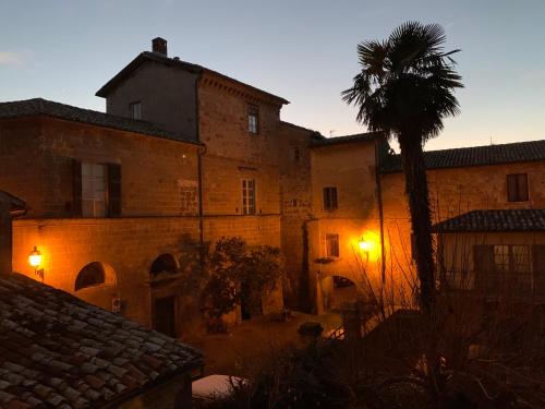 an old building with a palm tree in front of it at B&B La Casa Di Tufo in Orvieto