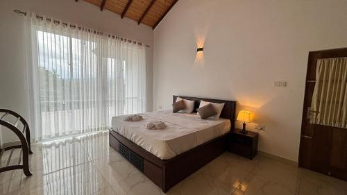 a bedroom with a bed and a large window at Chathu Holiday Home in Kandy