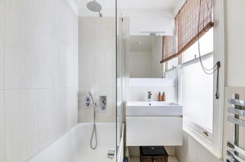 a white bathroom with a sink and a shower at Chancery's Loft Private Apartment in London