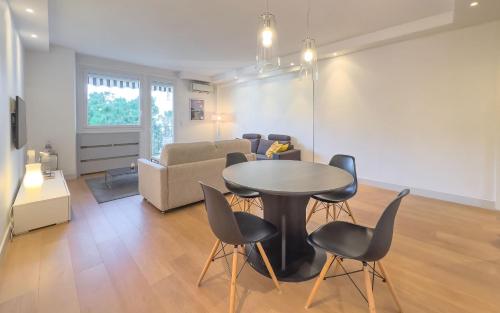 a living room with a table and chairs and a couch at Le Trendy by Winsome Destination in Cannes