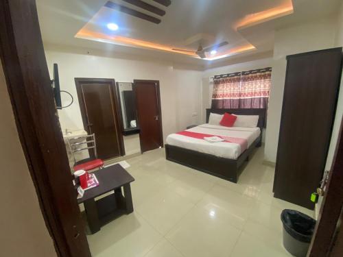a bedroom with a bed and a table in it at HOTEL MOUNTAIN PARADISE in Bangalore