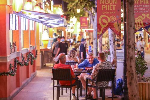 a group of people sitting at a table outside a restaurant at LITTLE PHU QUOC STUDIO in Phu Quoc