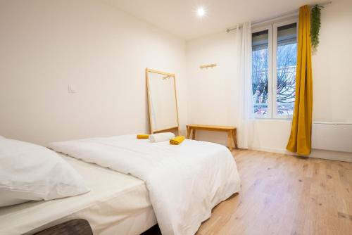 a bedroom with a white bed and a window at Budget apart city centre with parking in Charleville-Mézières