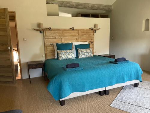 a bedroom with a large bed with blue sheets and pillows at Ferienhaus Côté Dentelles am Fuß der Dentelles de Montmirail in Vacqueyras