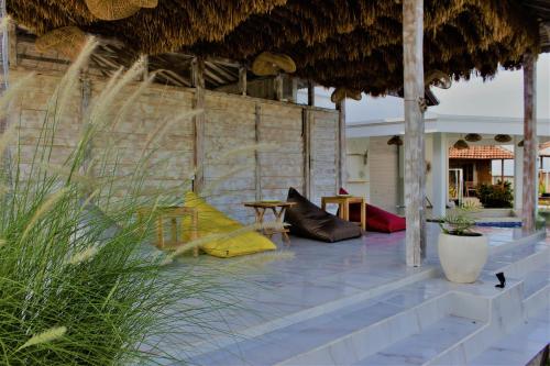 a patio with a table and chairs and a straw umbrella at Green Village Jungle Resort in Nusa Penida