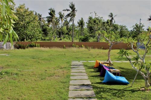 a garden with a rock path and a park with trees at Green Village Jungle Resort in Nusa Penida