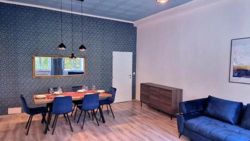 a dining room with a table and chairs and a couch at Luxury Three-Bedroom Apartment in Teplice