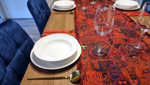 una mesa con platos y copas de vino en una mesa en Luxury Three-Bedroom Apartment, en Teplice