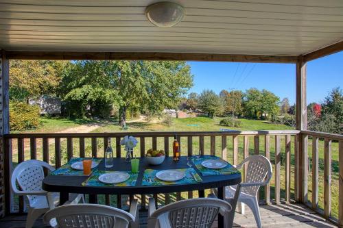 une table sur une terrasse avec une table et des chaises dans l'établissement Camping Brin d'Amour, à Les Eyzies-de-Tayac