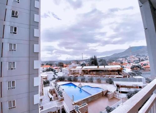 Batulicin的住宿－Mugiwara Hotel&Apartment，从带游泳池的大楼的阳台上可欣赏到风景