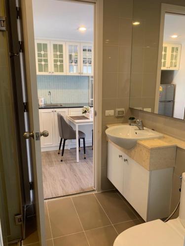 a bathroom with a sink and a table at The Blu X Seaview บางแสน F5 R140 in Ban Bang Saen (1)