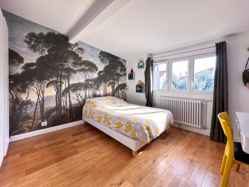 a bedroom with a bed and a painting on the wall at Magnifique maison familiale - Idéalement située pour les JO 2024 in Colombes