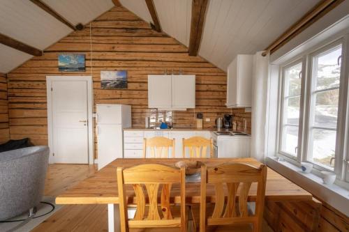 eine Küche mit einem Tisch und Stühlen im Zimmer in der Unterkunft Explorers Cabin Lofoten Edge in Sørvågen
