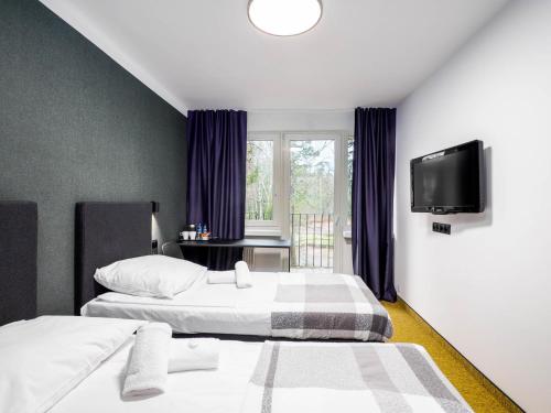 a hotel room with two beds and a television at 'Reset in Spała