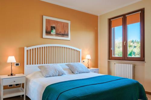 a bedroom with a large bed with a blue blanket at I BROLI - lovely nest with pool in Polpenazze del Garda