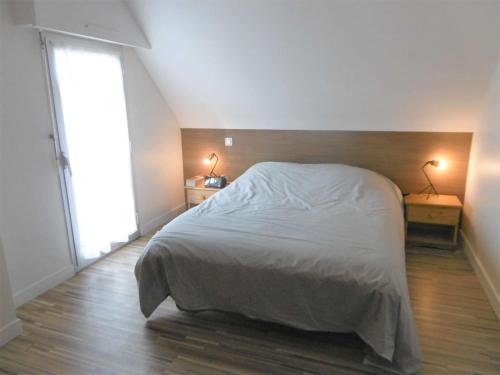 une chambre avec un lit blanc et une grande fenêtre dans l'établissement Maison 3 pièces 4 personnes - LAORA, à Sarzeau