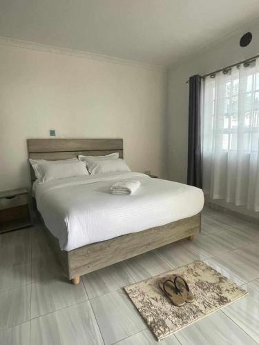 Un dormitorio con una cama grande con dos zapatos. en Maara Lodge Chogoria, en Igoji